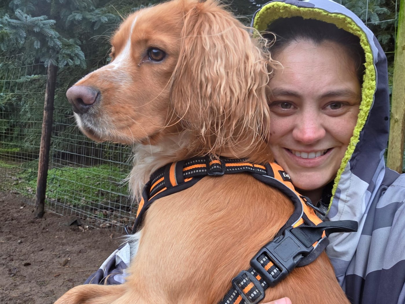 Danielle holding a calm spaniel in a secure outdoor area